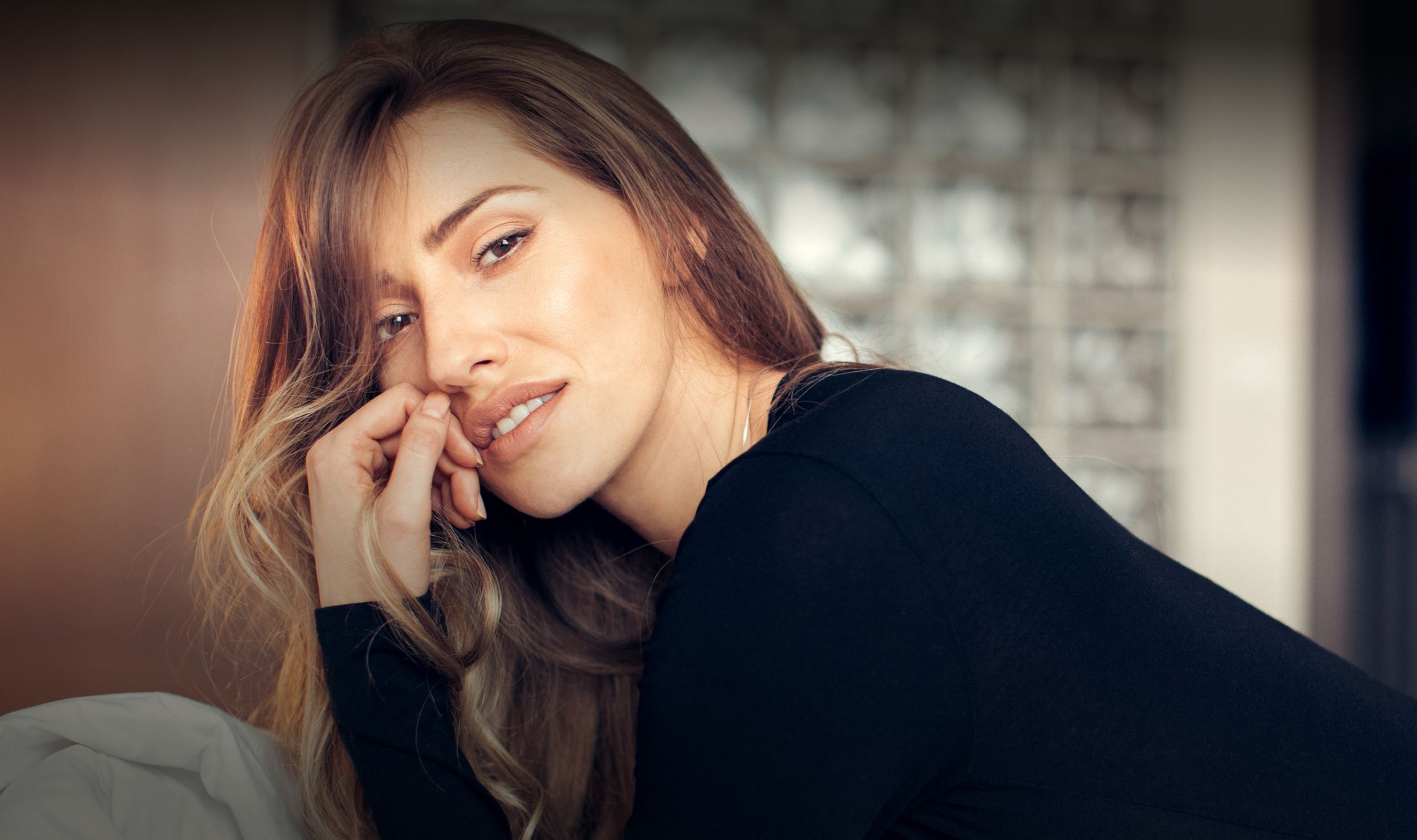 Woman resting with thoughtful expression indoors.